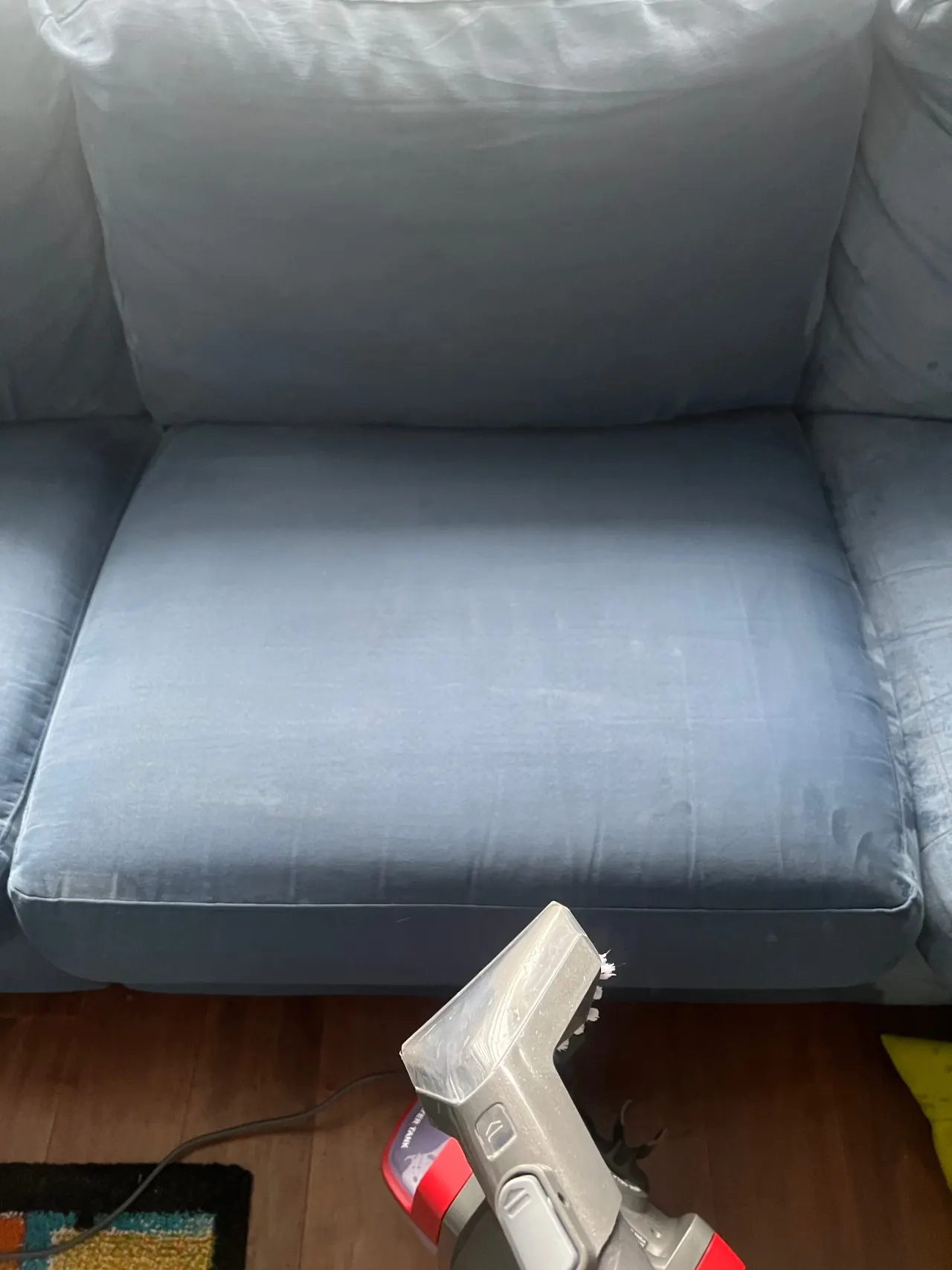 Blue velvet couch being professionally upholstery cleaned