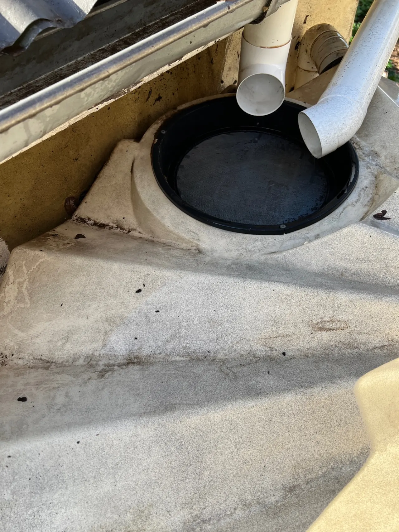Gutter cleaning after — downpipe and tank inlet cleared of debris